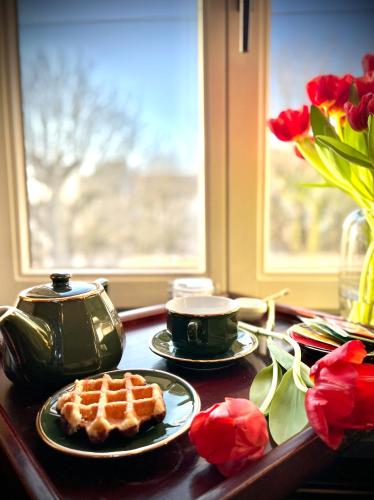 a table with a waffle on a plate and flowers at L'atique by Agelandkaai be with Parking in Ghent