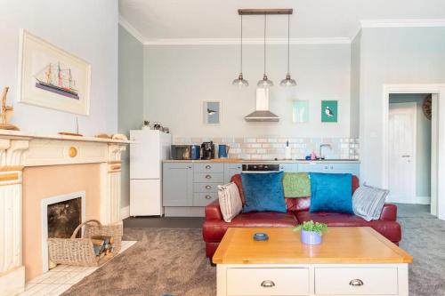a living room with a red couch and a fireplace at Beach Retreat in Lytham St Annes