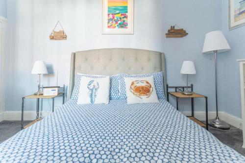 a blue bedroom with a large bed with pillows at Beach Retreat in Lytham St Annes