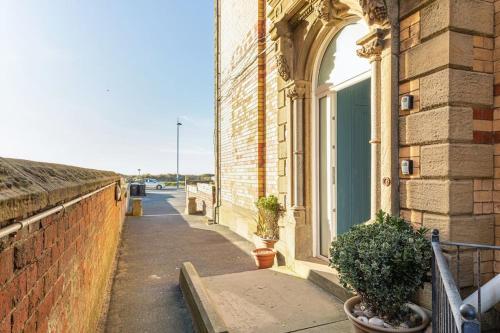 a building with a window and plants on a sidewalk at Beach Retreat in Lytham St Annes