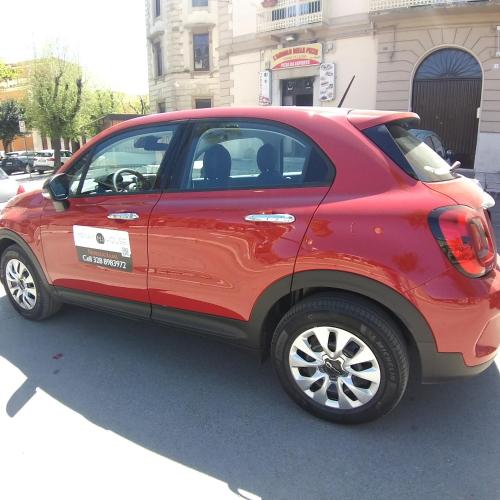 a red car parked in a parking lot at Miryam House Affittacamere Suite e Relax in San Severo