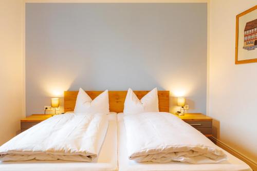 a bedroom with two beds with white pillows at Fränkische Landherberge, Hotel Garni in Seßlach