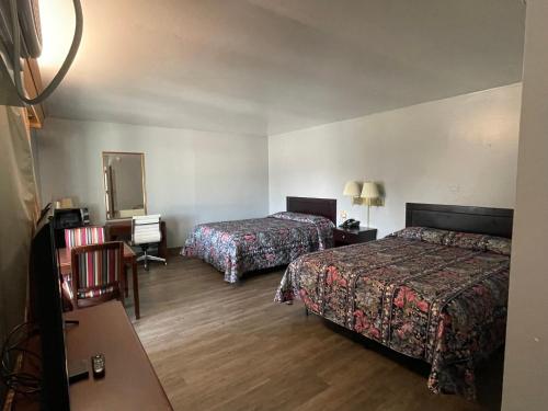 una camera d'albergo con due letti e uno specchio di Executive Inn a Marshalltown