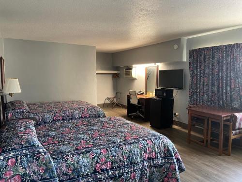 una camera d'albergo con 2 letti e una scrivania di Executive Inn a Marshalltown