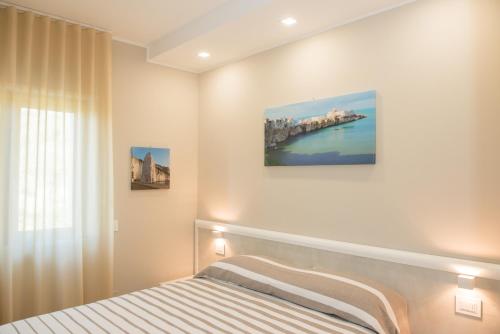 een slaapkamer met een bed en een schilderij aan de muur bij Aqua Sea Relais, Luxury Apartment & Pool in Vieste