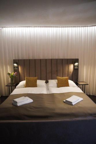 a bedroom with a large bed with two towels on it at Hotel Svambersky dum in Český Krumlov