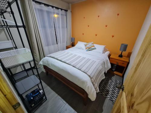 Fully-equipped 2-bedroom apartment in San José في سان خوسيه: غرفة نوم بسرير وسلم ونافذة