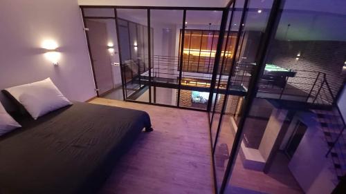 a small bedroom with a bed and a balcony at loft d architecte spa sauna billard 12 places ultra contemporain in Ferrière-la-Grande