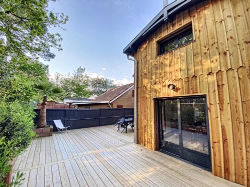 une terrasse en bois à côté d'une maison dans l'établissement Villa Chantaco Bassin Arcachon, à Gujan-Mestras