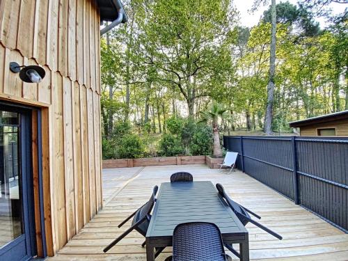 een terras met een tafel en stoelen bij Villa Chantaco Bassin Arcachon in Gujan-Mestras