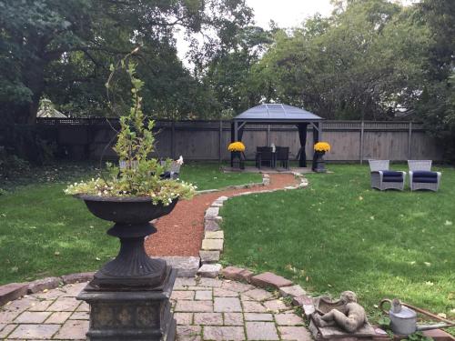 a garden with a statue and a gazebo at Old Ivy Walk in Niagara on the Lake
