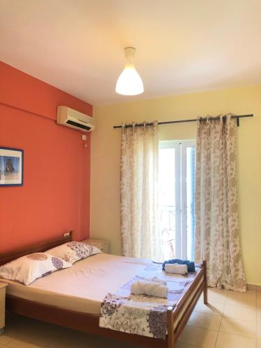 a bedroom with a bed and a window at Veizi's Apartments in Himare