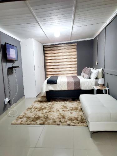 a bedroom with a bed and a couch at Beloved Lodge in Kimberley