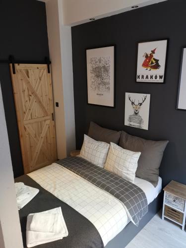 sypialnia z łóżkiem i drewnianymi drzwiami w obiekcie Klimatyczne mieszkanie w sercu Starego Podgórza w Krakowie