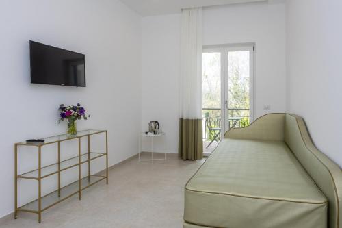 a living room with a couch and a tv at Villa Maìki in Torca