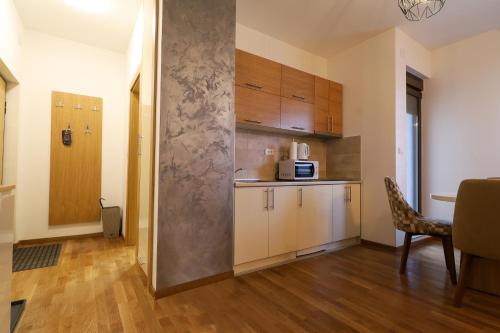 um quarto com uma cozinha com uma mesa e um micro-ondas em Apartman Zlatibor Renome em Zlatibor