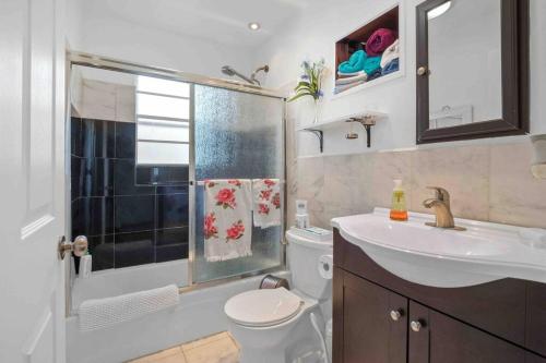 a bathroom with a toilet and a sink and a shower at Cozy house to call home away from home in Maryland Heights