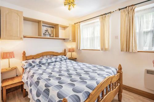 een slaapkamer met een bed en 2 ramen bij Sail Loft Annexe in Yarmouth