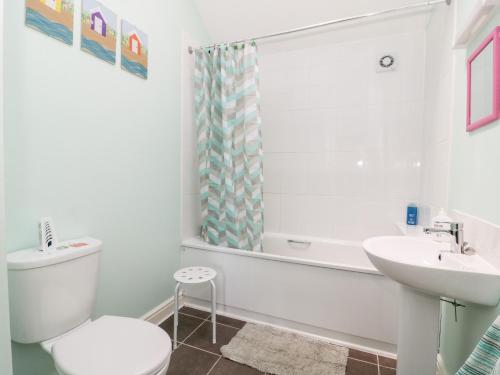 een witte badkamer met een toilet en een wastafel bij 2 Pines Farm Cottages in Ulleskelf