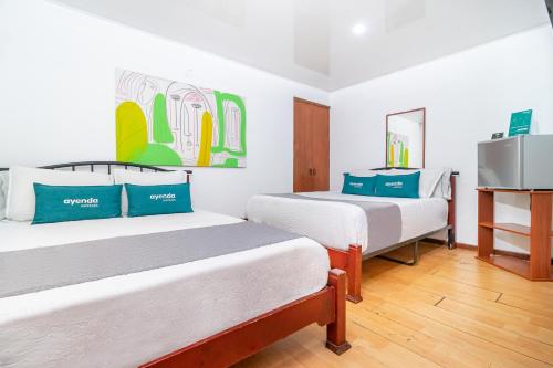 Pokój z dwoma łóżkami i telewizorem w obiekcie Ayenda 1032 Titas House w mieście Bogota