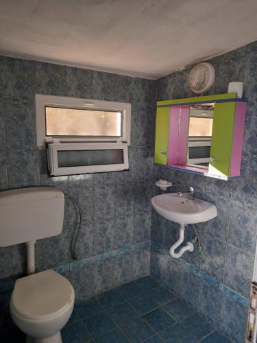 a bathroom with a sink and a toilet and a window at Peter's Sea House in Himare