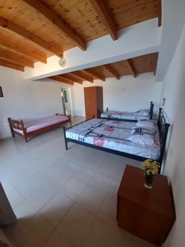 a bedroom with two beds and a table in it at Peter's Sea House in Himare