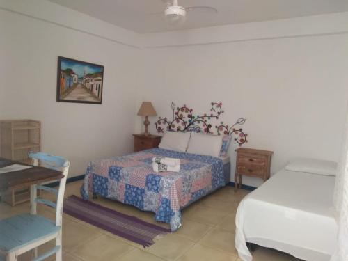 Schlafzimmer mit einem Bett, einem Schreibtisch und einem Bett in der Unterkunft Eco suites Caravelas in Cabo Frio