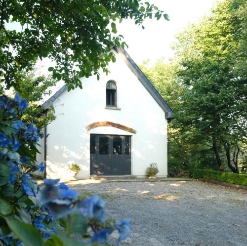 einen Blick auf eine weiße Kirche mit einer schwarzen Tür in der Unterkunft Dromdiah Lodge in Killeagh