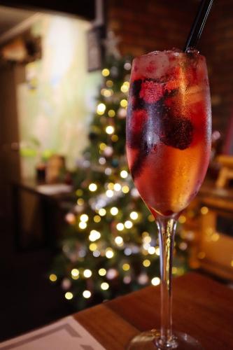 a glass of wine sitting on a table next to a christmas tree at Parklands Motorlodge & Holiday Park in Turangi