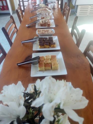 a long wooden table with plates of food on it at Cachoeira do Alemão - Recanto dos Arcos in Balsa Nova