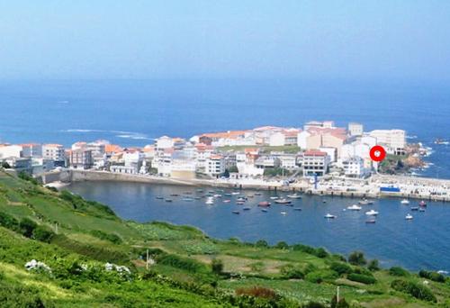 a city with a harbor with boats in the water at Vila Mariña. Casa marinera con terraza sobre el mar en Caión in Cayón