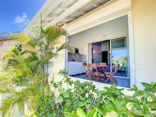 un balcone di una casa con tavolo e sedie di Beautiful suite S11, pool, sea view, Pinel Island a Cul de Sac