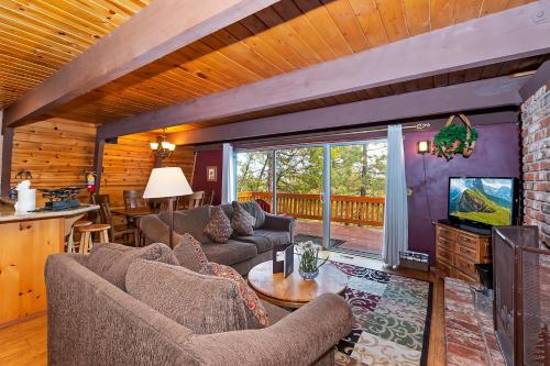 a living room with couches and a television in a cabin at 070 - Tree Top Villa in Big Bear Lake