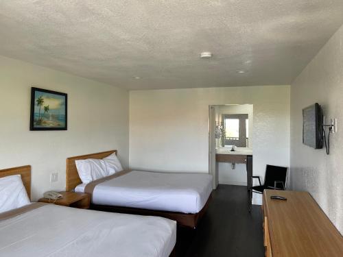 Voodi või voodid majutusasutuse Palms Inn & Suites toas