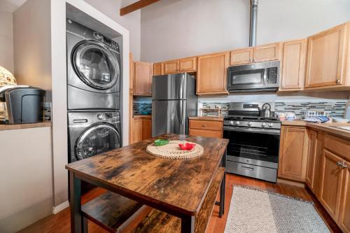 a kitchen with a wooden table and stainless steel appliances at 060 - The Angeles Chalet in Big Bear City