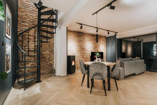 a dining room with a brick wall and a table and chairs at Rezydencja Bieszczady - Solina in Solina