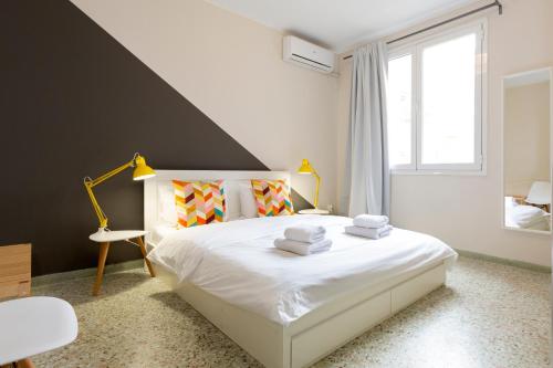 a bedroom with a white bed with towels on it at Psirri Place economy apartments centrally located in Athens