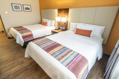Katil atau katil-katil dalam bilik di LATAM HOTEL Plaza Pradera Quetzaltenango