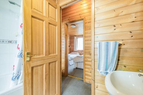 La salle de bains est pourvue de toilettes, d'un lavabo et d'une porte. dans l'établissement Rosy Lodge, à Milford on Sea
