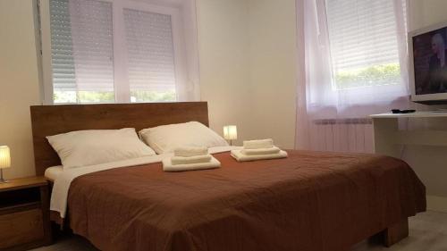 ein Schlafzimmer mit einem Bett mit zwei Handtüchern darauf in der Unterkunft San Lorenzo Apartments in Lovrečica