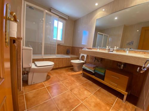 ein Badezimmer mit einem WC, einem Waschbecken und einem Spiegel in der Unterkunft house on the beach in Calafell