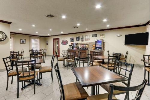 a restaurant with tables and chairs and a television at Best Western Plus University Inn & Suites in Wichita Falls