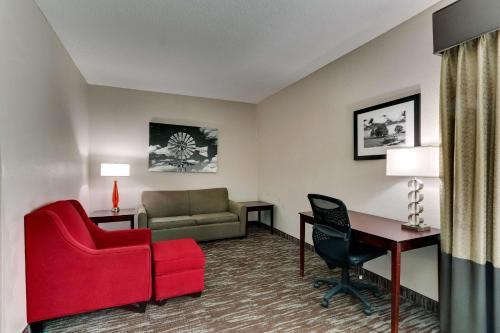 a hotel room with a red chair and a desk at Best Western Plus University Inn & Suites in Wichita Falls