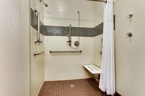 a bathroom with a shower with a bench in it at Best Western Plus University Inn & Suites in Wichita Falls