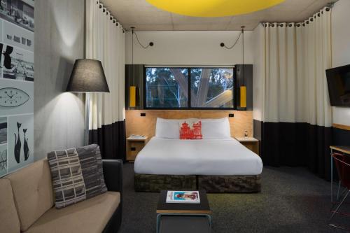 a hotel room with a bed and a couch at Atura Blacktown in Blacktown
