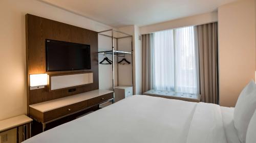 a hotel room with a bed and a flat screen tv at Best Western Premier Empire State Hotel in New York