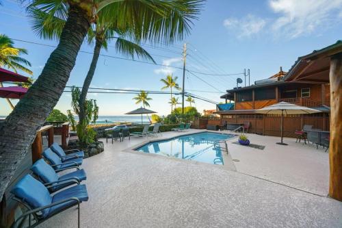 a house with a swimming pool and some palm trees at Ocean View 2 Bedroom Kahalu'u Reef in Kailua-Kona