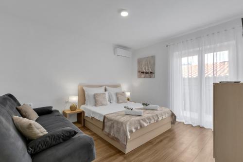 a white bedroom with a bed and a couch at Villa AMore Brela in Brela