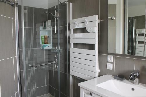 une salle de bain avec une douche, un lavabo et un miroir dans l'établissement Villa bord de mer spacieuse piscine chauffé privative, à Bretignolles-sur-Mer