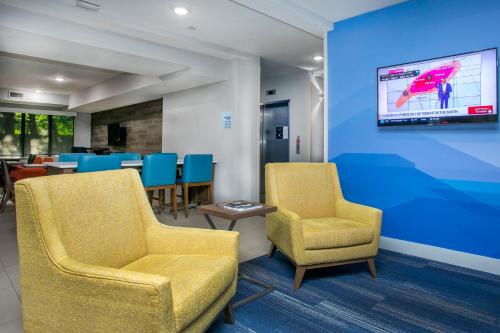 a waiting room with two chairs and a tv at Holiday Inn Express & Suites Jacksonville - Atlantic Beach by IHG in Jacksonville
